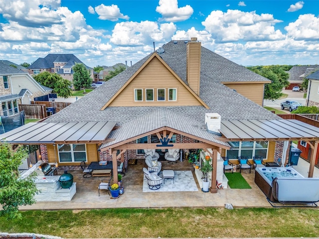 rear view of house with outdoor lounge area, exterior bar, a patio area, exterior kitchen, and a hot tub