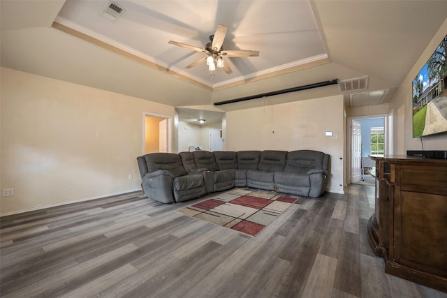 living room featuring a tray ceiling, ceiling fan, ornamental molding, and hardwood / wood-style flooring