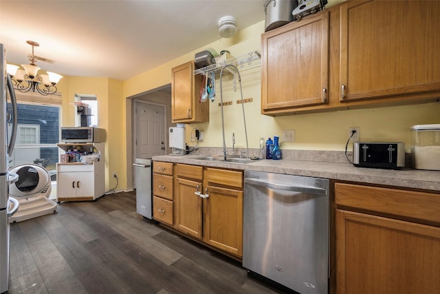 kitchen featuring dark wood-type flooring, sink, hanging light fixtures, stainless steel dishwasher, and a notable chandelier