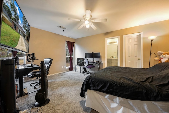 bedroom with ceiling fan, light colored carpet, and connected bathroom