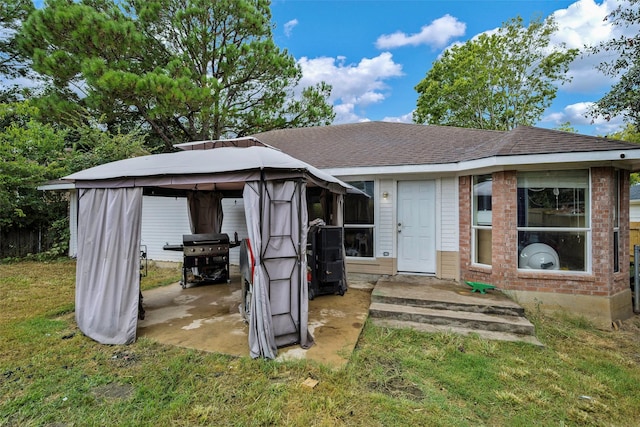 back of house featuring a gazebo and a lawn