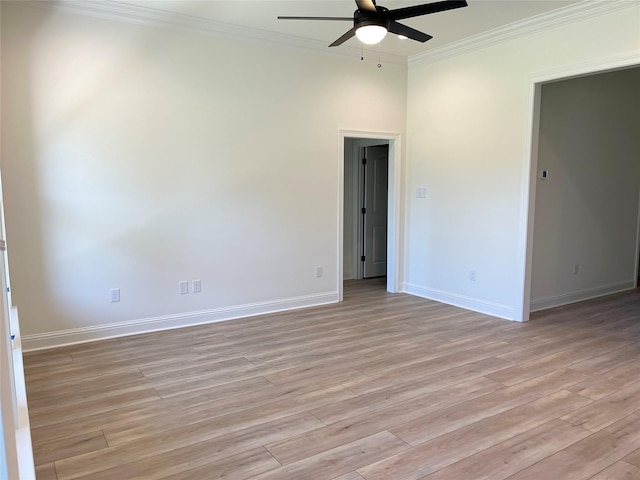 spare room featuring light wood-type flooring, ornamental molding, baseboards, and ceiling fan