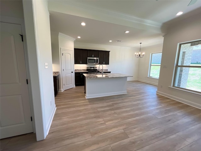kitchen with an inviting chandelier, appliances with stainless steel finishes, light wood-style flooring, baseboards, and ornamental molding