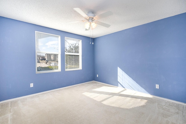 carpeted spare room with ceiling fan and a textured ceiling