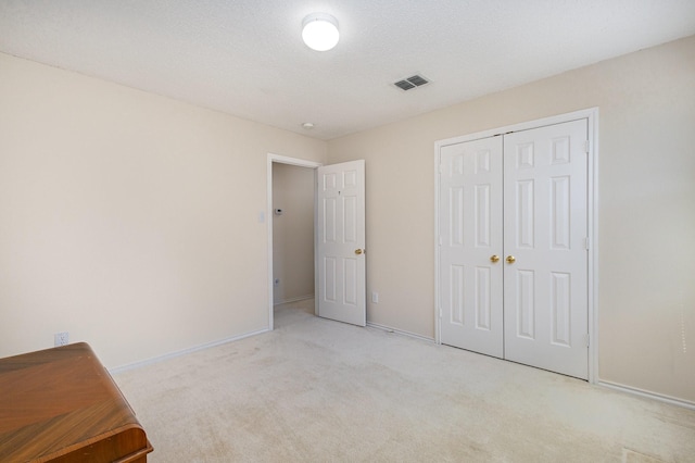 unfurnished bedroom featuring light carpet and a closet