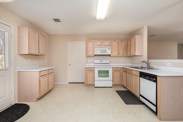 kitchen featuring sink, white appliances, a textured ceiling, and light brown cabinets