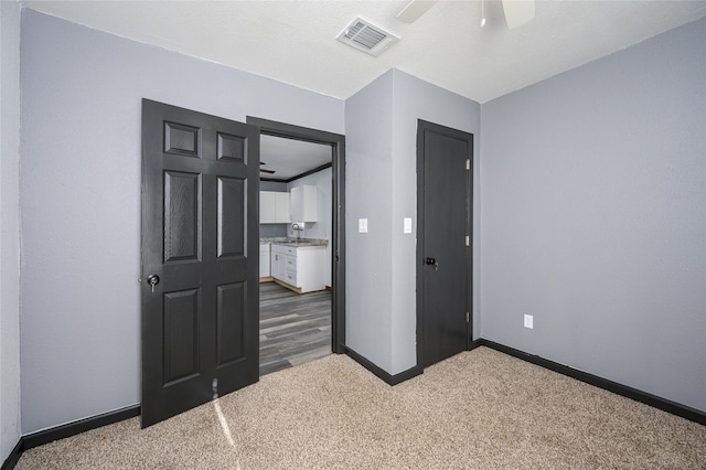 unfurnished bedroom with ceiling fan and carpet