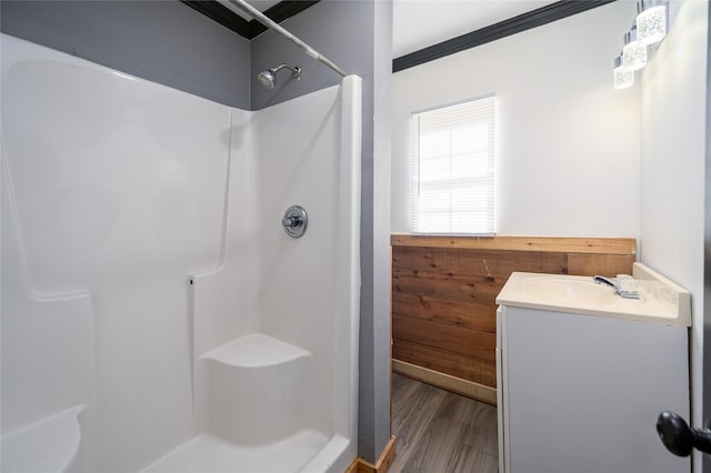 bathroom with walk in shower, vanity, and hardwood / wood-style flooring