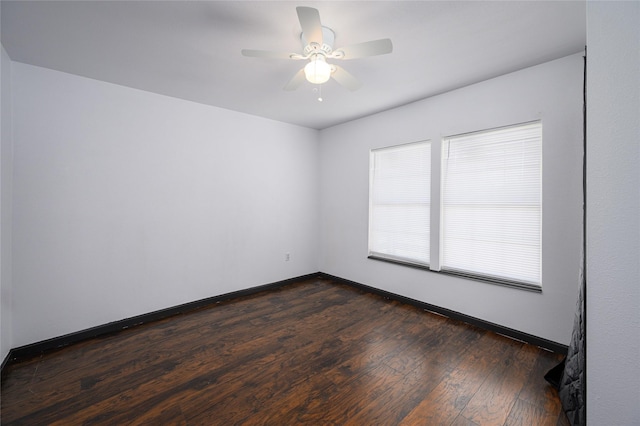 empty room with ceiling fan and dark hardwood / wood-style flooring