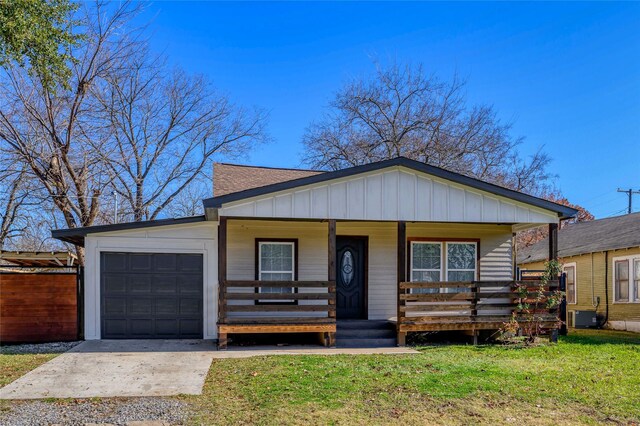 view of front of house with central AC, a front lawn, a porch, and a garage