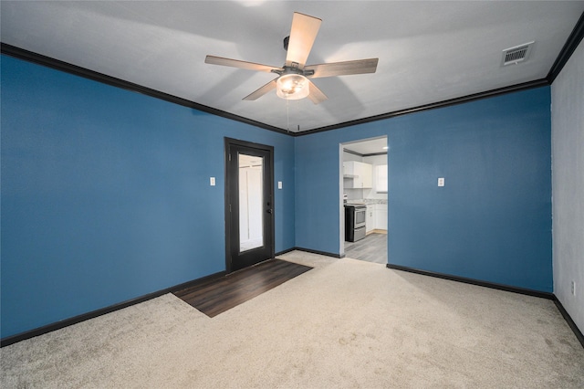 carpeted empty room with ceiling fan and ornamental molding