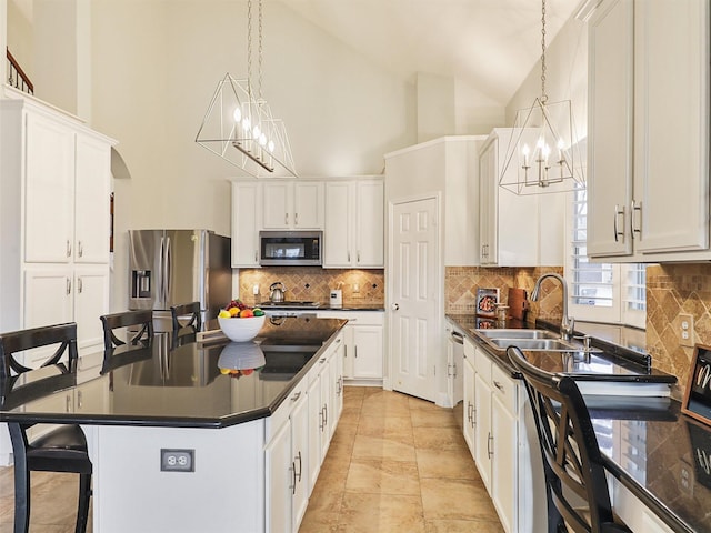 kitchen featuring white cabinets, appliances with stainless steel finishes, pendant lighting, and sink