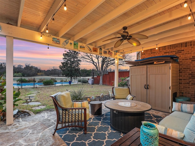 patio terrace at dusk with ceiling fan, a swimming pool, and an outdoor hangout area