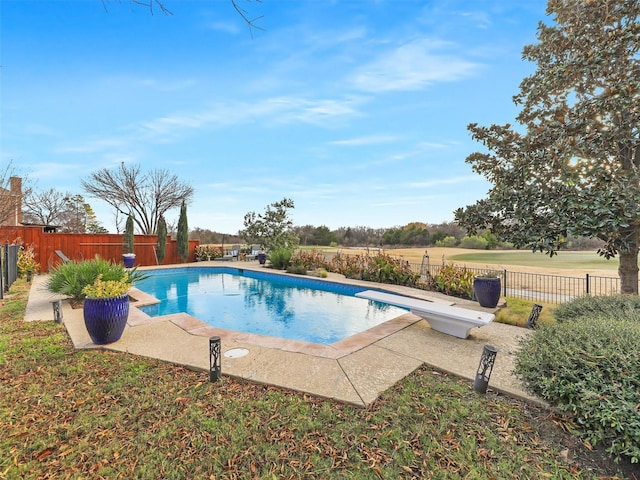 view of swimming pool with a diving board