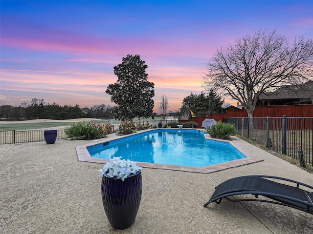 pool at dusk featuring a patio area