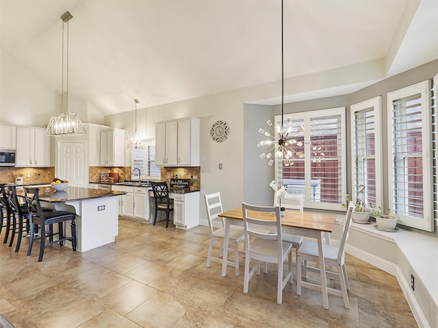 kitchen featuring lofted ceiling, a center island, white cabinets, and decorative light fixtures