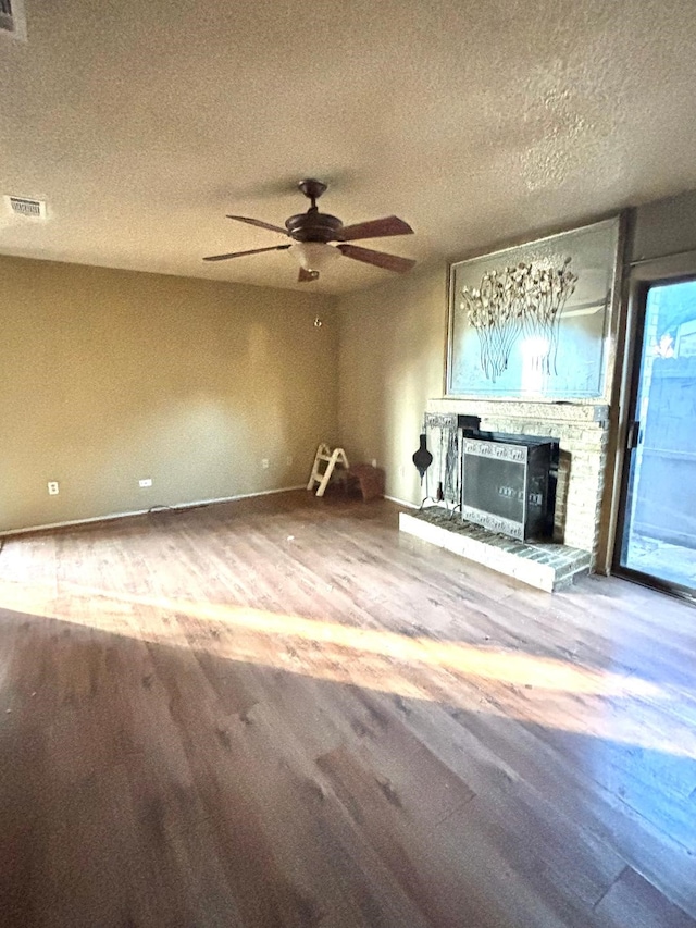 unfurnished living room featuring wood-type flooring, a textured ceiling, and ceiling fan