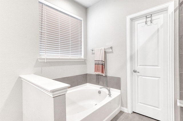 bathroom featuring tile patterned flooring and a tub to relax in