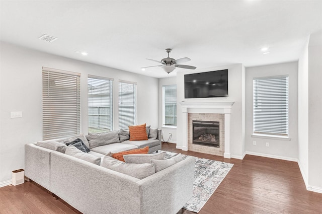 living room featuring dark wood-type flooring and ceiling fan