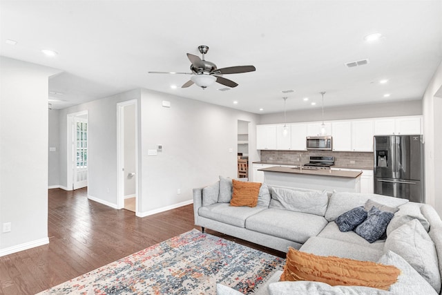 living room featuring dark wood-type flooring and ceiling fan