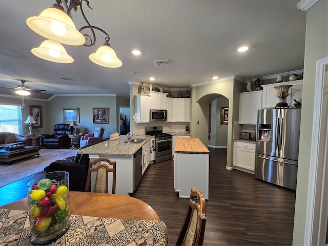 kitchen featuring butcher block counters, sink, appliances with stainless steel finishes, a kitchen island, and pendant lighting