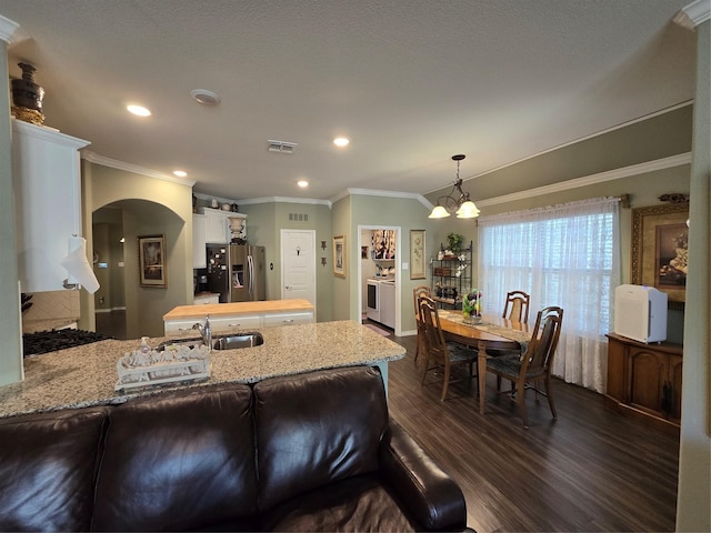 kitchen featuring white cabinetry, stainless steel refrigerator with ice dispenser, light stone countertops, dark hardwood / wood-style flooring, and decorative light fixtures