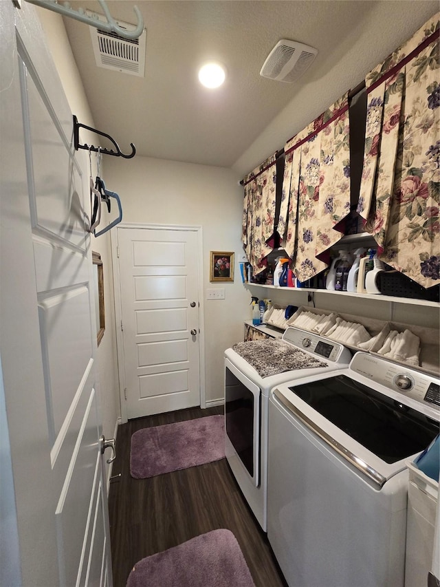 washroom with washing machine and clothes dryer and dark hardwood / wood-style flooring