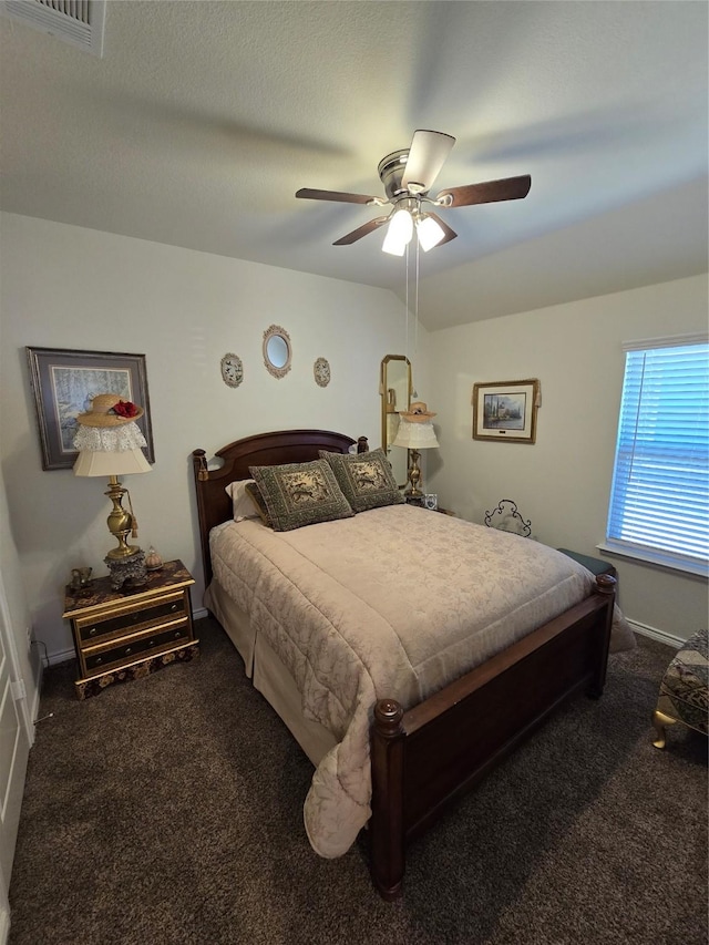 carpeted bedroom featuring a textured ceiling and ceiling fan