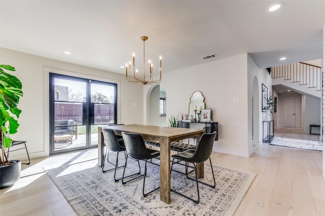 dining space with a notable chandelier and light wood-type flooring