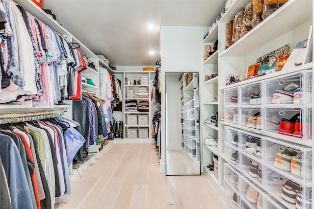 walk in closet with light hardwood / wood-style floors