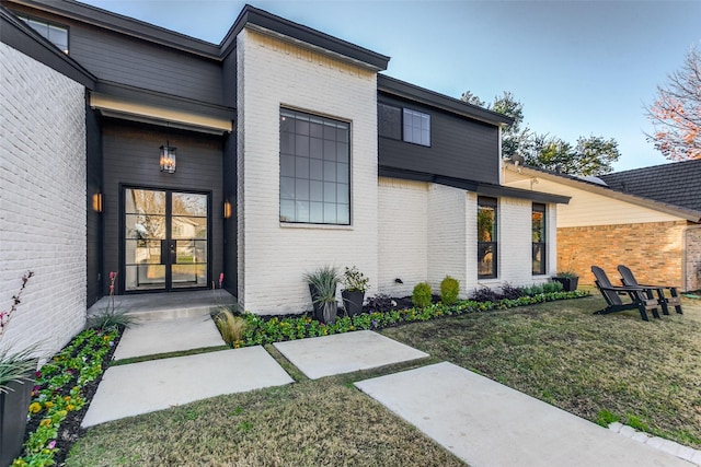 view of exterior entry with a lawn