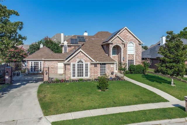 view of property with a front yard and solar panels