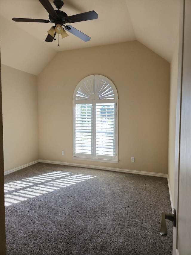 carpeted spare room featuring ceiling fan and lofted ceiling