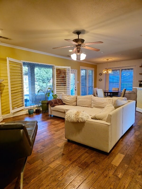 living room with ornamental molding, ceiling fan, and dark wood-type flooring