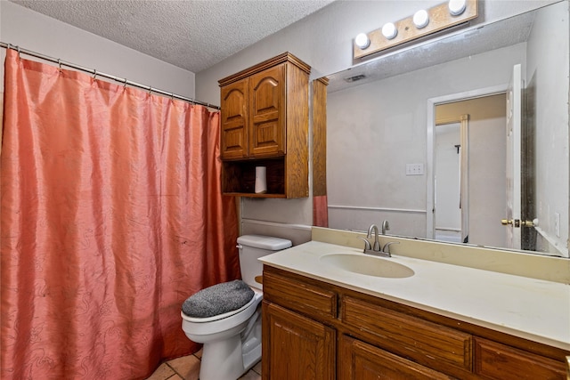 bathroom with vanity, toilet, tile patterned flooring, and a textured ceiling