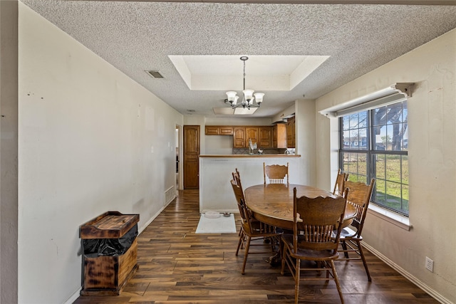 dining area with a textured ceiling, an inviting chandelier, a wealth of natural light, and dark wood-type flooring