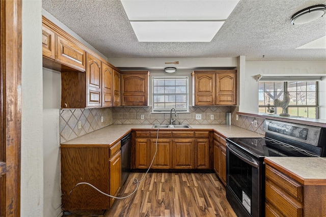 kitchen with dark wood-type flooring, decorative backsplash, sink, and black appliances