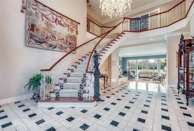 entryway with a high ceiling, crown molding, a notable chandelier, and light tile patterned flooring