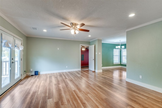 spare room featuring crown molding, french doors, light hardwood / wood-style floors, and ceiling fan with notable chandelier