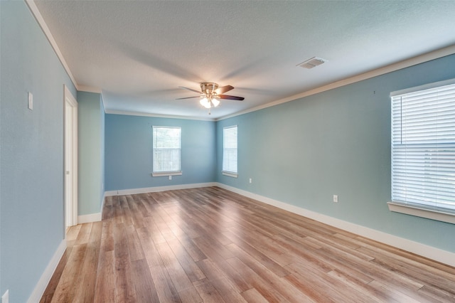 unfurnished room featuring ceiling fan, light hardwood / wood-style floors, ornamental molding, and a textured ceiling