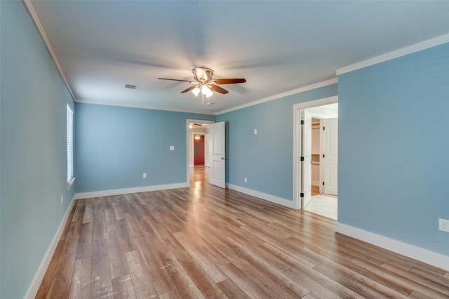 empty room featuring ceiling fan, light wood-type flooring, and crown molding