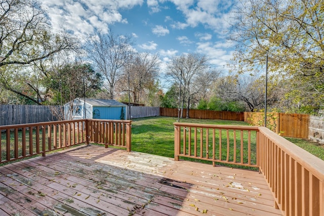 wooden deck featuring a storage shed and a lawn