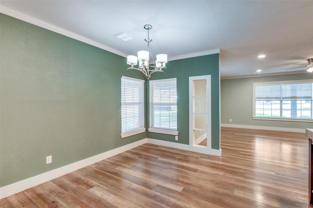 unfurnished dining area with wood-type flooring, ceiling fan with notable chandelier, and crown molding