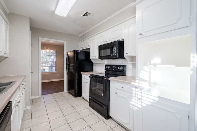 kitchen featuring black appliances, light tile patterned floors, tasteful backsplash, white cabinetry, and a chandelier