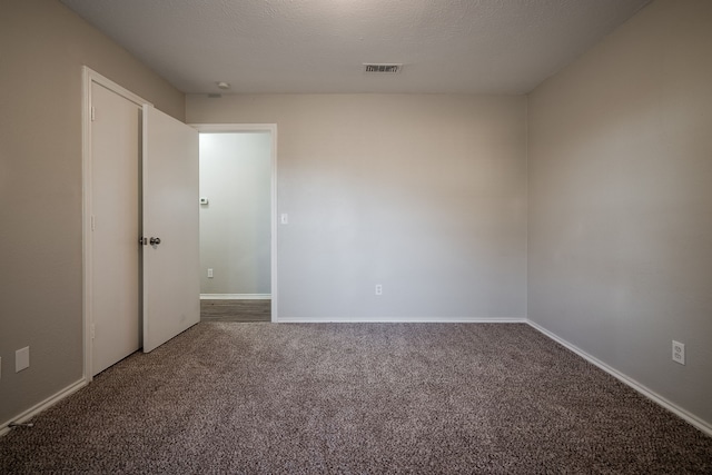 carpeted empty room with a textured ceiling