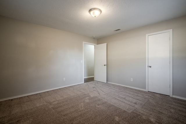 carpeted spare room featuring a textured ceiling