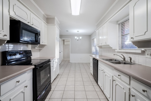 kitchen featuring white cabinets, hanging light fixtures, and black appliances