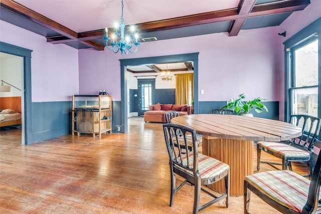 dining area featuring beamed ceiling, hardwood / wood-style floors, an inviting chandelier, and coffered ceiling