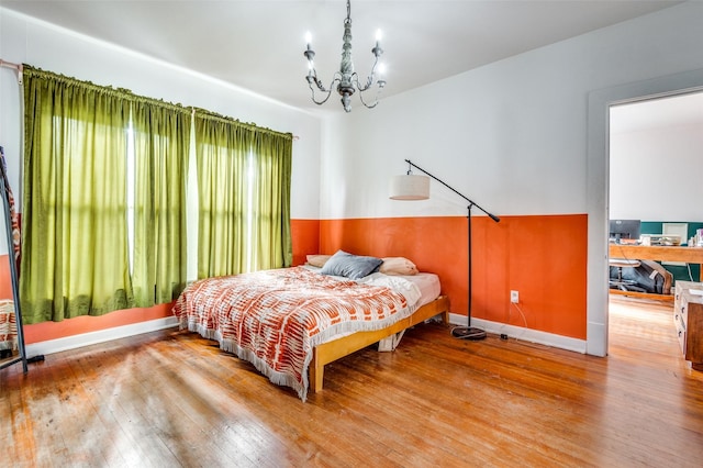 bedroom with hardwood / wood-style floors and a chandelier