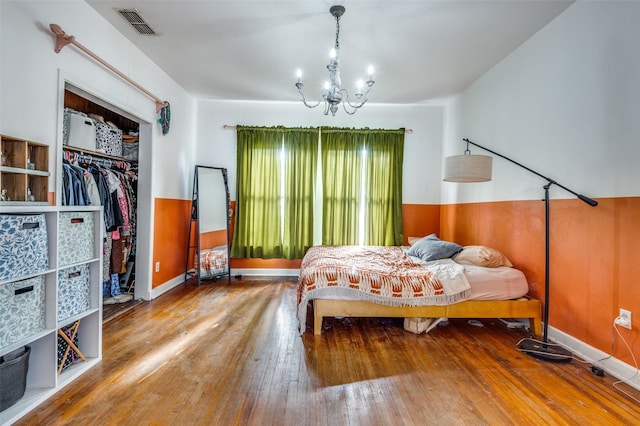 bedroom featuring a chandelier, hardwood / wood-style floors, and a closet